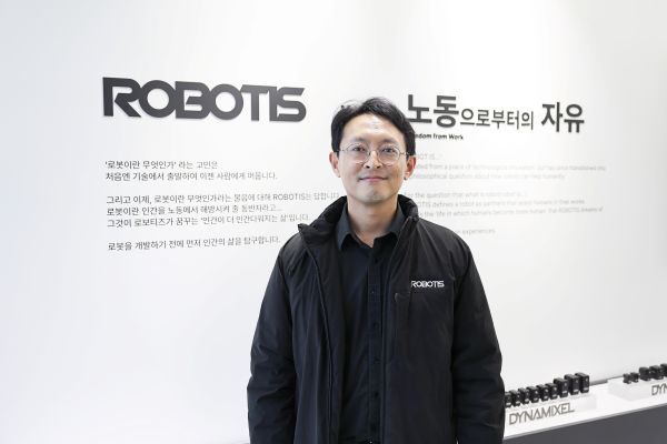 로보티즈 현판앞에 서있다